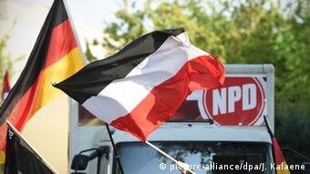 German flags in front of an NPD sign. (Photo: Jens Kalaene/dpa)