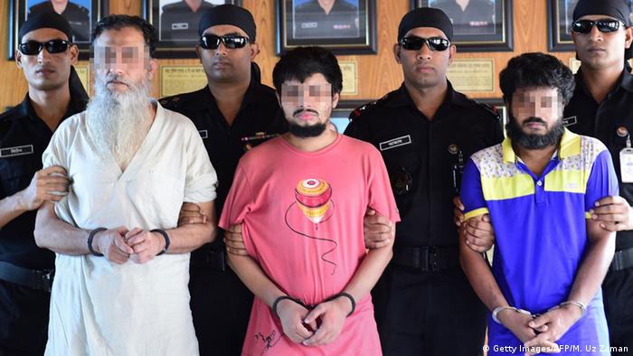 Bangladeshi Rapid Action Battalion personnel accompany suspects Touhidur Rahman, (2L), Sadek Ali (C) and Aminul Mallick (2R), who have been arrested for the murder of two prominent atheist bloggers, during a media photocall in Dhaka on August 18, 2015 (Photo: MUNIR UZ ZAMAN/AFP/Getty Images)