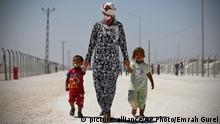 Syrian refugees walk around a refugee camp in Suruc, on the Turkey-Syria border, Friday, June 19, 2015. Ahead of World Refugee Day on Saturday, June 20, 2015, the UN refugee agency, UNHCR, estimated that a total of 11.6 million people from Syria had been displaced by the conflict by the end of last year, the largest such figure worldwide. Turkey is the world's biggest refugee host with 1.59 million refugees, according to the most recent U.N. figures. (AP Photo/Emrah Gurel)