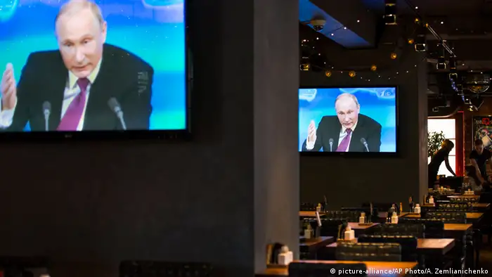 Wladimir Putin auf Fernsehbildschirmen während einer Pressekonferenz im Dezember 2014.