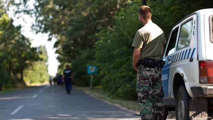 A field guard watches law enforcement procedures at the border