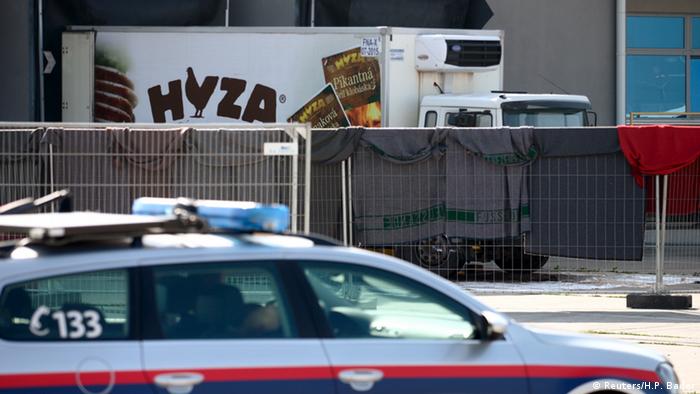 На заднем плане - фура, в которой были обнаружены тела беженцев