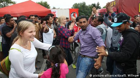 Flüchtlinge und Unterstützer tanzen gemeinsam auf einem Willkommensfest für Flüchtlinge in Heidenau 
Foto: picture-alliance/dpa/S. Willnow
