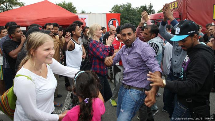 Flüchtlinge und Unterstützer tanzen gemeinsam auf einem Willkommensfest für Flüchtlinge in Heidenau 
Foto: picture-alliance/dpa/S. Willnow
