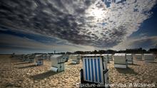 dpatopbilder Über den Strandkörben des Ostseebades Rostock-Warnemünde (Mecklenburg-Vorpommern) kämpft sich die Sonne am 25.08.2015 durch die Wolken. Das hochsommerliche Wetter ist vorerst vorbei. Foto: Bernd Wüstneck/dpa