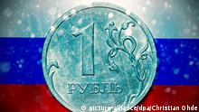 Ein-Rubel-Münze vor russischer Fahne mit Schneefall, wirtschaftliche Folgen von Sanktionen gegen Russland