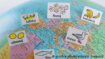 Auf einem Atlas, der Europa und einen Teil Afrikas zeigt, sind in Frankfurt am Main mehrere Zettel mit Esperanto-Wörtern und deren bildlicher Darstellung zu sehen