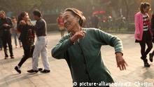 --FILE--An elderly Chinese woman dances on a square in the morning in Luoyang city, central China's Henan province, 24 October 2014. Square dancing, the exercise craze popular with middle-aged women urbanites but less so with those sensitive to loud music, is to get more support from local authorities after an edict from the central government. New cultural and sporting venues being built by local authorities should include facilities for the activity, according to a circular issued on Sunday (6 September 2015), which also advised authorities to provide free dance classes and teaching materials. The activity, which usually involves groups of dozens or even hundreds of mainly middle-aged women exercising in public squares and parks, has proved controversial, with conflicts arising between dancers and residents who complain of ear-splitting music. Square dancing is a cultural and sporting activity greatly favoured by the mass society, said the circular. It plays a positive role in enriching people's spiritual life and encourages everybody to take part in sport and [helps to make them happy], added the circular, which was issued by the central government's cultural, sporting, civil affairs and housing authorities.