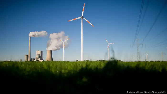 A coal power plant and a wind turbine (Photo: Julian Stratenschulte/dpa)