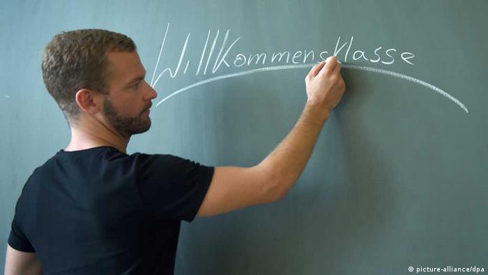 Ein Lehrer schreibt an der Tafel 'Willkommen' (Foto: Foto: Britta Pedersen)