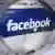 Facebook logo seen through magnifying glass Photo: Arno Burgi/dpa