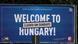 A billboard reads 'Welcome to Hungary! Closed on Sundays' A billboard reads 'Welcome to Hungary! Closed on Sundays'
