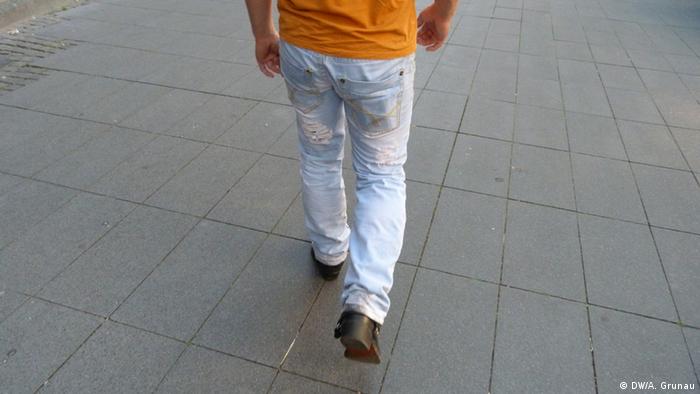 Blick auf Beine und Unterkörper eines Mannes, der über einen Gehweg läuft (Foto: DW/Andrea Grunau)