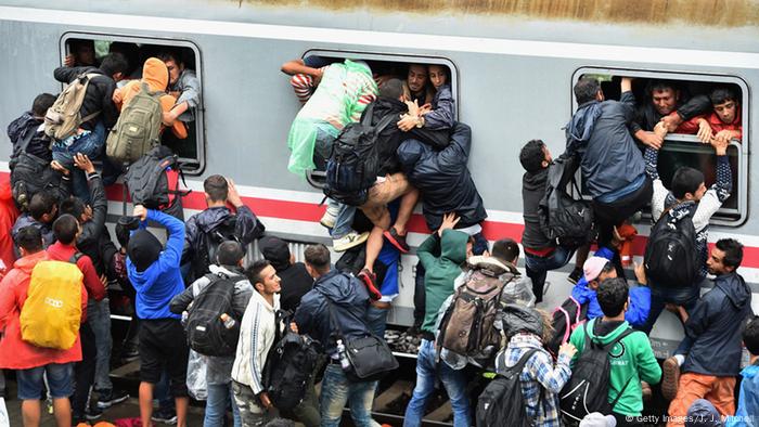 Refugees try to board a crowded train 