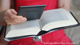 Eine Fau mit einem eReader und einem Buch in den Händen