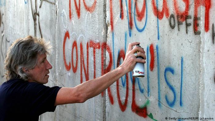 Roger Waters sprüht ein Graffiti an die Mauer in Bethlehem.