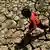 Child running over drought-struck land