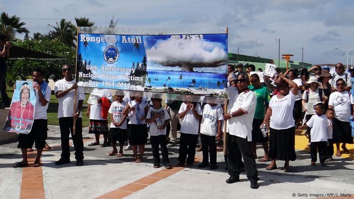 Habitantes de las Islas Marschall protestan aquí por lo que se considera un crimen de lesa humanidad contra la población de los Territorios de Prueba del Océano Pacífico. En Bikini y Rongerik Estados Unidos ensayó más de 20 bombas de hidrógeno y atómicas entre 1946 y 1958. La población indígena fue expulsada. Los políticos y la radioactividad los desterraron para siempre.