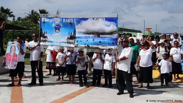 Habitantes de las Islas Marschall protestan aquí por lo que se considera un crimen de lesa humanidad contra la población de los Territorios de Prueba del Océano Pacífico. En Bikini y Rongerik Estados Unidos ensayó más de 20 bombas de hidrógeno y atómicas entre 1946 y 1958. La población indígena fue expulsada. Los políticos y la radioactividad los desterraron para siempre.