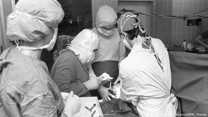 Black and white image of doctors and nurses performing an operation