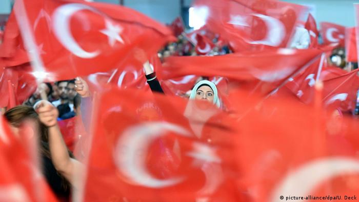 Anhänger des türkischen Staatspräsidenten Recep Tayyip Erdogan schwenken türkische Nationalflaggen