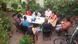 A group of people sitting in green courtyard A group of people sitting in green courtyard