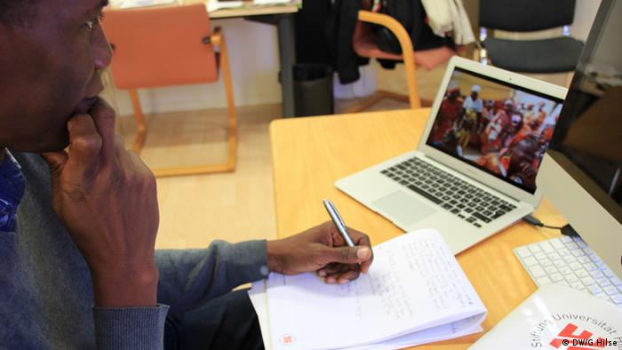 Christopher Mtaku vor einem Laptop mit Aufnahmen aus Nigeria (Foto: DW/G. Hilse)