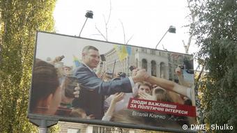 Ukraine Kommunalwahl Vitali Klitschko auf einem großen Plakat wie er Menschenmenge die Hände entgegenstreckt (Quelle: © Evgenij Shulko)