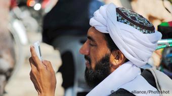 Man looking at his mobile phone in Pakistan (photo: picture alliance)