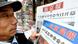 A man reads Chinese newspapers A man reads Chinese newspapers