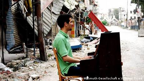 Pianist Ayham Ahmad plays the keys on a bomb-shattered street of Damascus