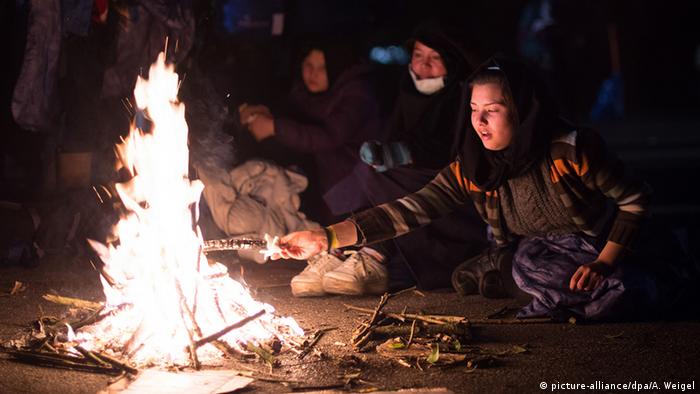 Беженцы греются у ночного костра