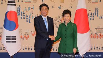Shinzo Abe und Park Geun-Hye beim Handschlag vor den beiden Landesflaggen (Foto: Reuters/Yonhap/L. Jung-hoon)