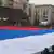 Растянутое вдоль улицы полотнище российского флага на демонстрации в Москве
