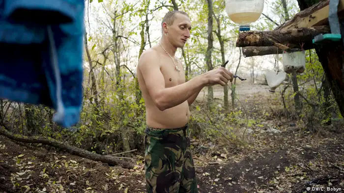 A marine shaves on an autumn morning on the Donetsk front