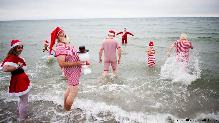 Costumed participants of the World Congress of Santa Clauses enter the water during the annual swim at Bellevue beach, north of Copenhagen, Denmark. 