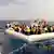 Die Italienische Küstenwache bei der Rettung afrikanischer Flüchtlinge, die auf einem Boot übers Mittelmeer wollen (Foto: picture alliance/ROPI)