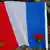 Die französische Flagge liegt mit einer Rose auf dem Boden. (Foto: Reuters/H. Hanschke)