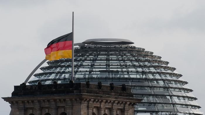 The German Reichstag building with a flag flying at half-mast
