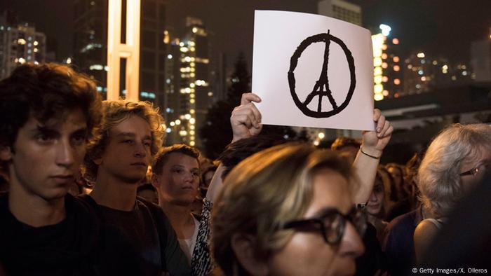 Weißes Peace-Schild mit Eiffelturm in der Mitte wird aus einer Menschenmenge hochgehalten. (Getty Images/X. Olleros)