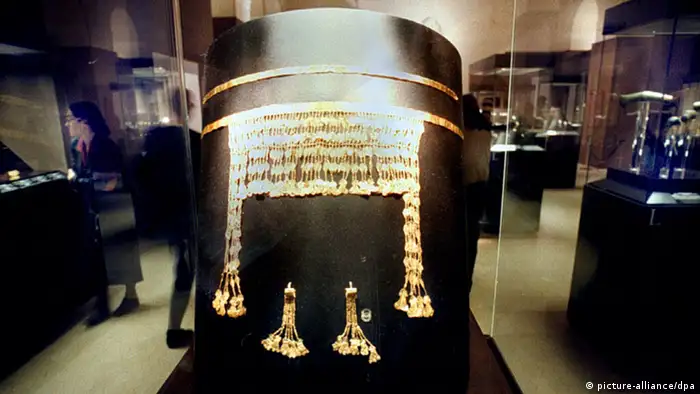 A golden head dress and earrings in a museum display.