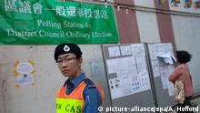 22.11.2015*** epa05037247 A Civil Aid Service officer standing guard outside a polling station in Choi Wan South in Wong Tai Sin District during Hong Kong's District Council elections, Ping Shek Estate, East Kowloon, Hong Kong, China, 22 November 2015. Due to a surge in young people registering to vote in the post-Occupy Central / Umbrella Movement political landscape, voter turnout this year's District Council election has been higher than in 2007 and 2011. EPA/ALEX HOFFORD +++(c) dpa - Bildfunk+++