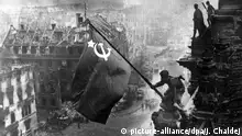 ARCHIV - Der sowjetische Soldat Militon Kantarija aus Georgien hisst am 2. Mai 1945 die sowjetische Flagge auf dem Berliner Reichstag. Deutschland hatte den Zweiten Weltkrieg verloren. Foto: dpa +++(c) dpa - Bildfunk+++ Copyright: picture-alliance/dpa/J. Chaldej
