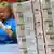Женщина складывает рублевые банкноты