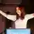 Argentinian President Cristina Fernandez raises her arms to acknowledge a crowd of supporters.