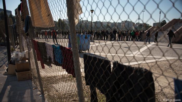 Male asylum-seekers lined up in the taekwondo stadium, Athens