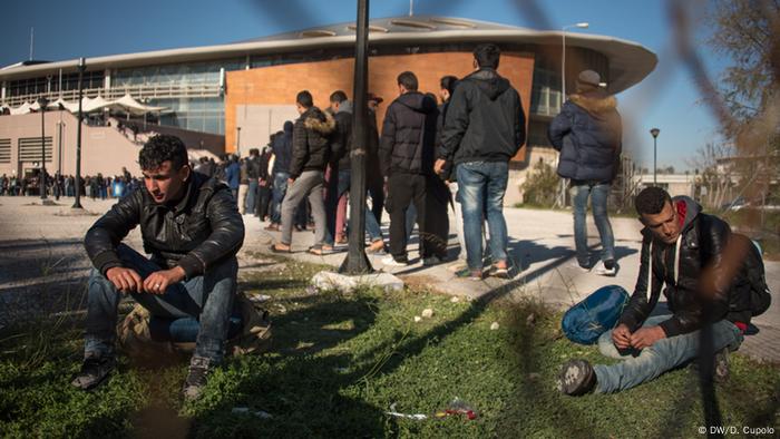Men stand in a food line on front of the taekwondo stadium