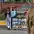 Pakistani students carry a banner bearing images of victims of the Peshawar school massacre as army troops cordon off a street leading to the Army Public School due to hold a ceremony to mark the first anniversary of the school massacre which left more than150 people dead, in Peshawar on December 16, 2015. Pakistan deployed paramilitary forces and police in major cities on December 16 as it marked the first anniversary of a Taliban school massacre that left 151 people dead, shocking a country already scarred by nearly a decade of attacks.