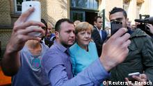 File photo of migrants from Syria and Iraq taking selfies with German Chancellor Angela Merkel outside a refugee camp near the Federal Office for Migration and Refugees in Berlin, Germany, September 10, 2015. Time magazine named German Chancellor Angela Merkel its 2015 Person of the Year on December 9, 2015, noting her resilience and leadership when faced with the Syrian refugee crisis and turmoil in the European Union over its currency this year. Reuters/F. Bensch/Files TPX IMAGES OF THE DAY