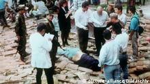 Polizeibeamte und Journalisten umringen die am Boden liegende Leiche des kolumbianischen Drogenbosses Pablo Escobar. Escobar ist am 2. Dezember 1993 während einer Polizeiaktion erschossen worden. Er hatte versucht, durch Flucht der Festnahme zu entgehen. © picture-alliance/Bildarchiv